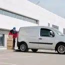 Delivery Man With Boxes next to a White Van