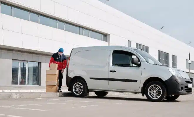 Delivery Man With Boxes next to a White Van