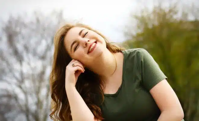 Une femme au T shirt vert souriante