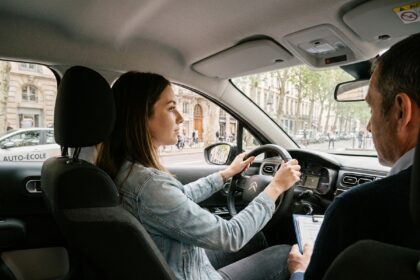 Jeune femme apprenant à conduire dans les rues de Lyon avec un moniteur d'auto-école