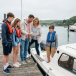 Famille montant à bord d'un petit bateau sans permis amarré dans un port de plaisance