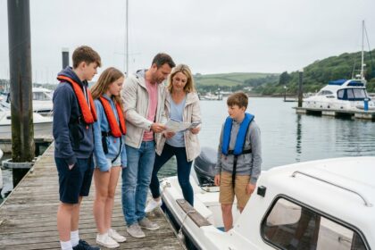 Famille montant à bord d'un petit bateau sans permis amarré dans un port de plaisance