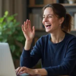 Femme qui rit pendant un appel visio depuis son bureau à domicile