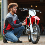 Jeune homme vérifiant la chaîne de son motocross rouge et blanc
