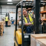 Ouvrier manutentionnaire manœuvrant un chariot élévateur dans un centre logistique