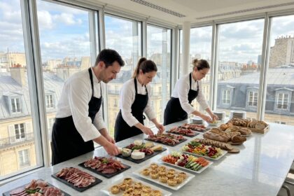 Équipe de traiteur professionnel dressant un buffet d'entreprise élégant dans une salle de réunion parisienne moderne